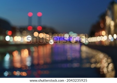 Defocused photography of Moscow cityscape in night. City in bright light. Heat station smoking  pipes. Blue sky. River is full of reflections. Concept of beauty of capital of Russian Federation. 