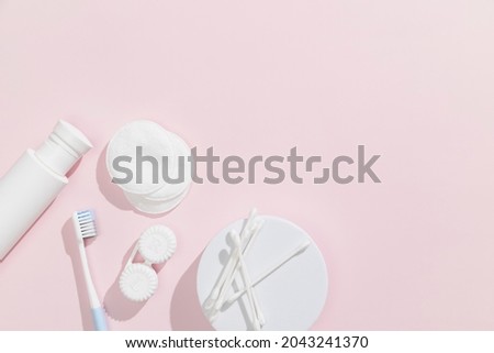 Ear sticks, cotton pads, toner (lotion) and toothbrush on pink background. Beauty and hygiene concept. High quality photo