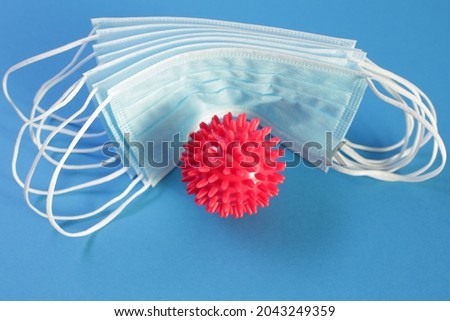 Viral Coronavirus Bacteria And Protective Medical Disposable Masks On A Blue Background. Concept Of Air Pollution , Pneumonia Outbreaks, Epidemics , And Prevention Of The Risk Of Biological Pollution
