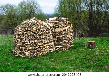 Drying and storage of firewood in the form of a House or a stack. Preparing firewood for winter Royalty-Free Stock Photo #2043275408