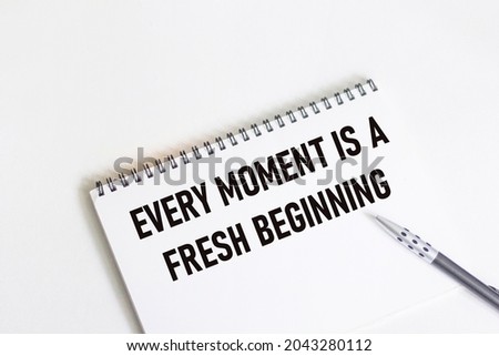 Every moment is a new beginning. Inspirational quote on notepad with pen.