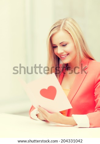 picture of woman holding postcard with heart shape.