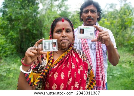 Rural Villager Couple Showing Aadhaar Card in agricultural field Royalty-Free Stock Photo #2043311387