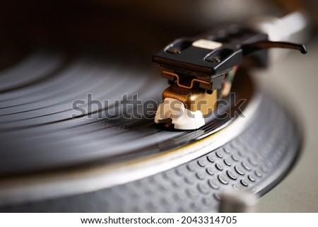 Retro turntable needle in close up. Dj deck playing vinyl record with music