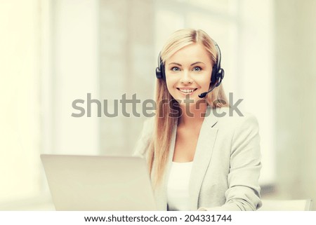 smiling female helpline operator with headphones and laptop