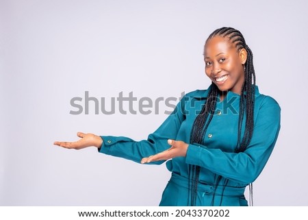 Woman showing pointing on background. Very fresh and energetic beautiful black africa young lady smiling happy presenting on white background.