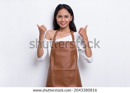 Asian woman Barista waitress wearing apron with ok sign gesture tumb up isolated on white background
