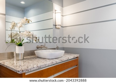 Urban condo powder room with round sink orchid marble countertop and grey walls Royalty-Free Stock Photo #2043392888