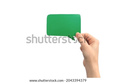 Hand with blank green speech bubble, isolated on a white background. Concept of giving feedback, communication and text message. Empty cardboard mockup