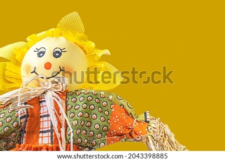 Smiling scarecrow on a harvest orange background.
