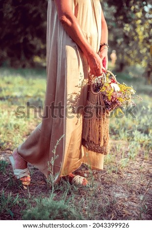 Beautiful wildflowers in the hands of a woman on a summer field. Summer mood