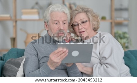 Happy Old Couple Using Tablet at Home