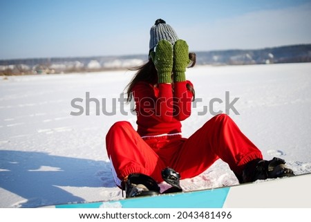 fashion winter photo of beautiful asian woman in sport clothes posing with snowboard in forest