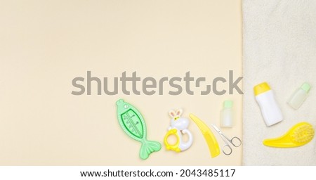 Baby shower accessories, towel and toy on light background with copy space