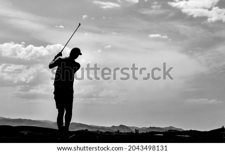 silhouette of a golfer swinging