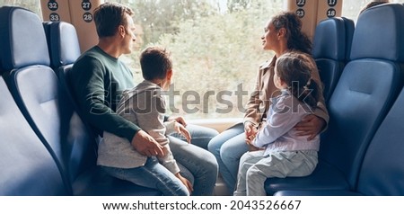 Family with two little kids enjoying train journey together Royalty-Free Stock Photo #2043526667