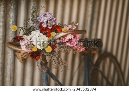Blue vintage bike leaning against wall with fresh flowers
