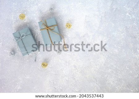 two grey giftboxes decorated silver and golden ribbons on the grey background, holiday concept, christmas, birthday, top view, copy space