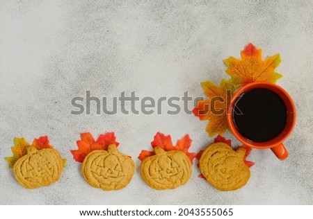 autumn halloween background fall leaves maple, sweet home made cookies shaped pumpkin,greeting card with copy space text,  thanksgiving day and festive baking item