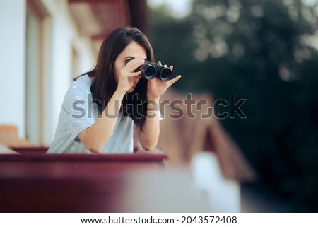 Curious Woman Holding a Pair of Binocular Spying on her Neighbors. Funny young person snooping and peeping from her balcony
 Royalty-Free Stock Photo #2043572408