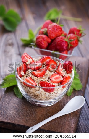 Oat flakes with strawberries  on wooden table. Selective focus.