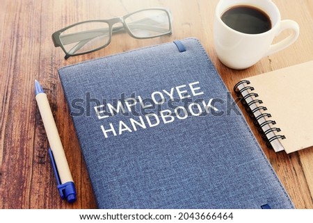 Concept image of employee handbook over wooden office table. top view Royalty-Free Stock Photo #2043666464