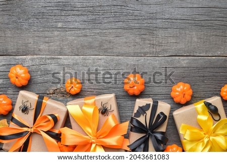 Halloween background with gifts and pumpkins on a wooden background. copy space. Flat layout, top view, a place to copy.