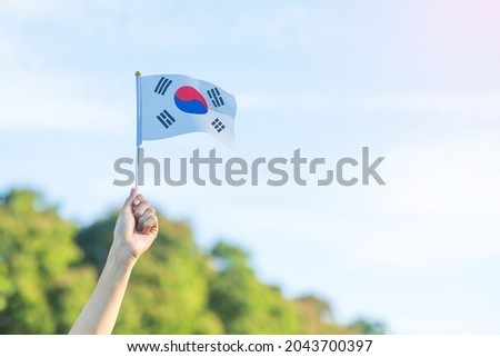 hand holding Korea flag on nature background. National Foundation, Gaecheonjeol, public Nation holiday, National Liberation Day of Korea and happy celebration concepts Royalty-Free Stock Photo #2043700397