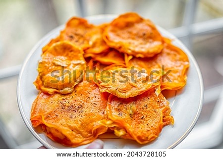 Macro closeup of woman holding white plate with butternut squash raw uncooked stuffed dehydrated ravioli Italian food with slices, extra virgin olive oil, pepper seasoning Royalty-Free Stock Photo #2043728105