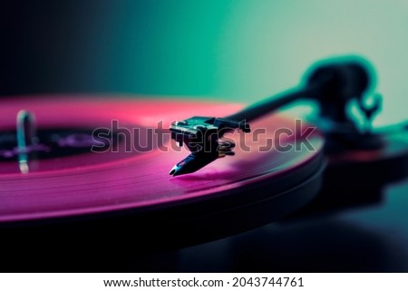 Vinyl DJ turntable in club lighting. close-up. pink tint Royalty-Free Stock Photo #2043744761