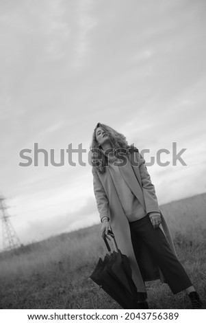 autumn photo shoot a girl and an umbrella, a walk through an autumn field, black and white film fuzzy photo