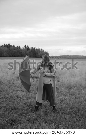 autumn photo shoot a girl and an umbrella, a walk through an autumn field, black and white film fuzzy photo
