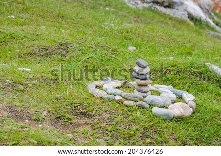 Rock Cairn marker on boulder against grass background