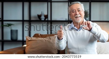 old senior retired asian male hand hold gesture and show covid-19 rapid test kit result with negative sign with happiness and cheerful,self test rapid test at home 