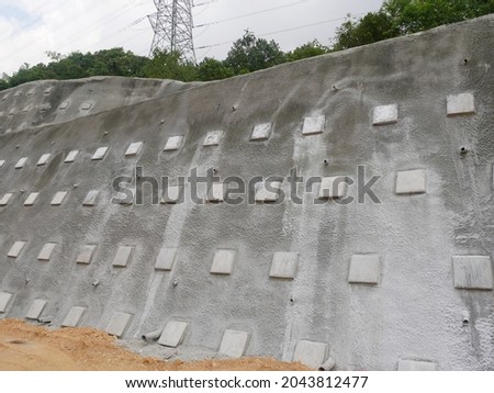Soil Nailing. It is a ground stabilization technique that can be used on either natural or excavated slopes. It involves drilling holes for steel bars to be inserted into a slope face.  Royalty-Free Stock Photo #2043812477