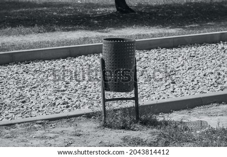 Metal garbage can. Metal trash can. Black and white photo. 