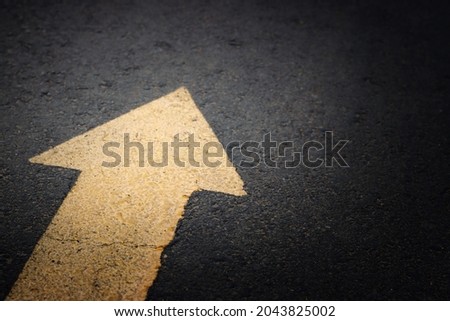 arrow sign on black asphalt texture