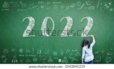 2022 Happy new year school class academic calendar with student kid's hand drawing greeting on teacher's green chalkboard for educational celebration, back to school, STEM education classroom schedule