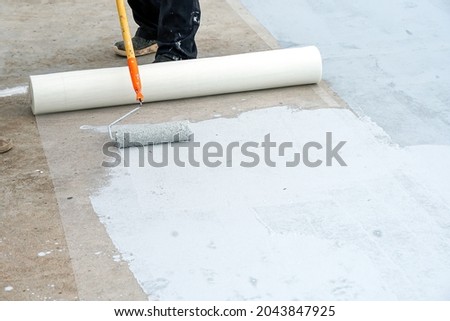 Hand painted gray flooring with paint rollers for waterproof, reinforcing net,Repairing waterproofing deck flooring.	          Royalty-Free Stock Photo #2043847925