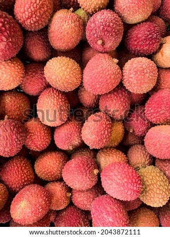 Lychee exotic fruit background. Full frame picture of harvested litchi fruits or berries. Asian food. Vertical. Selective focus