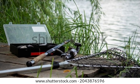 Fishing tackle on the river bank, bait rod, spinning rod, fish. Nature. Selective focus Royalty-Free Stock Photo #2043876596