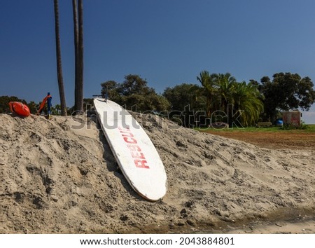 Lifeguard equipment on the sand. Rescue surf board, Bouie and flippers for lifeguard.