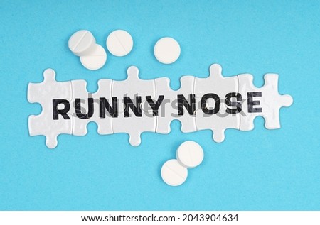 Medicine concept. On a blue background pills and puzzles with the inscription - Runny Nose