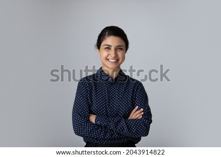 Head shot portrait smiling young Indian woman with arms crossed standing on grey studio background isolated, confident successful businesswoman or student with folded hands looking at camera Royalty-Free Stock Photo #2043914822