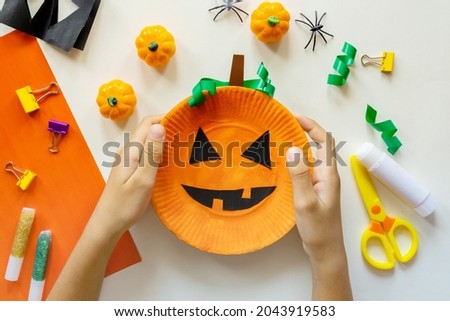 Cuts of paper for Halloween. Hand cut paper. Pumpkins. Scissors and glue. On a light background. Top view. Flat lay. DIY. Step by step. Trick or treat.