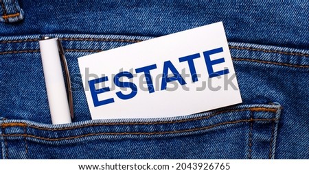 The back pocket of blue jeans contains a white pen and a white card with the text ESTATE