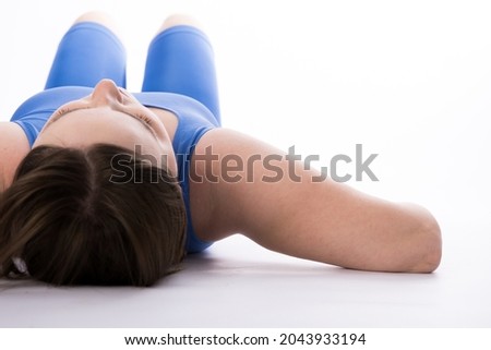 a girl of European appearance in a blue suit lies on the floor. checking the level of the collarbones. woman relaxing