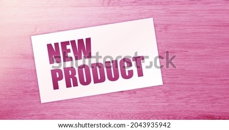 New Product words on card on wooden table. Business concept.