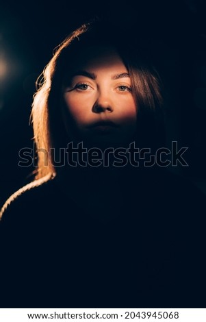 Domestic violence. Woman abuse. Female slavery. Sexism discrimination. Victim lady portrait focus on face in soft warm light shadow contrast isolated on dark free space background. Royalty-Free Stock Photo #2043945068