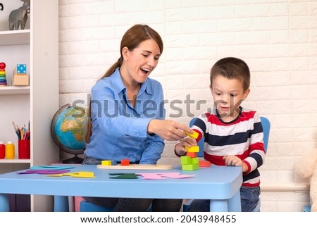 Toddler boy in child occupational therapy session doing sensory playful exercises with her therapist. Royalty-Free Stock Photo #2043948455